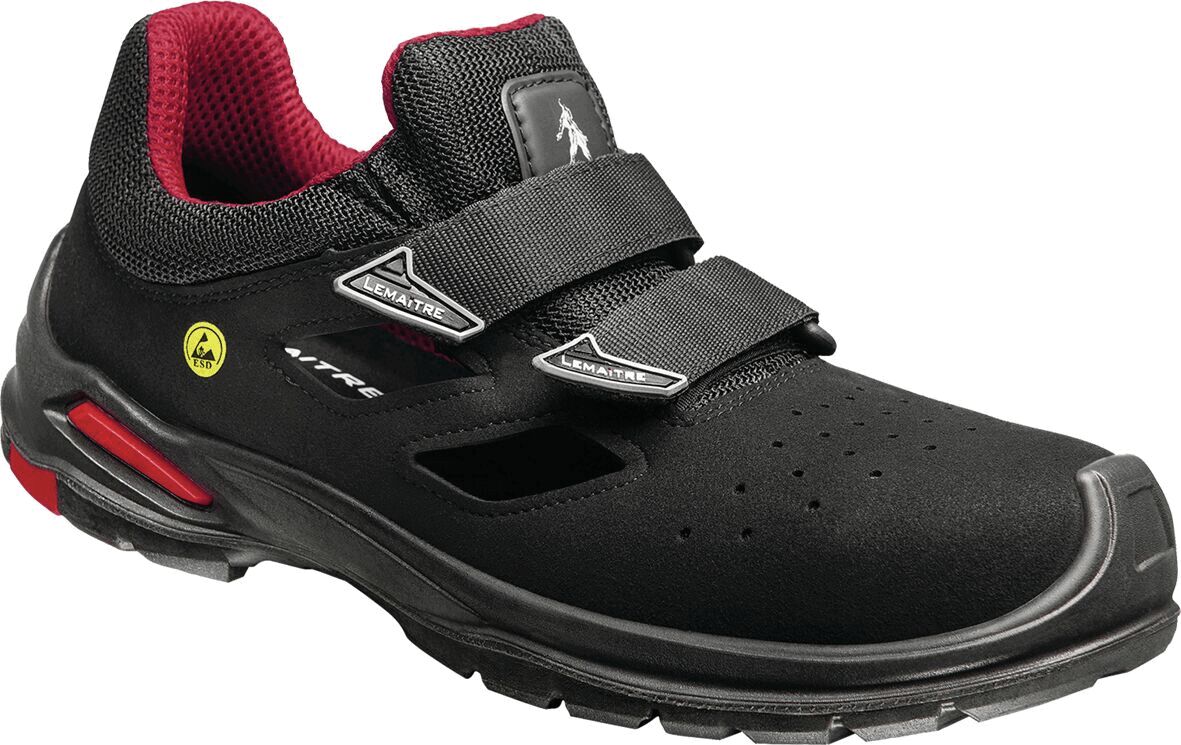 The shoe is black with red accents. It has a sporty design, two Velcro straps, and a perforated surface for ventilation. The sole is thick and stable.