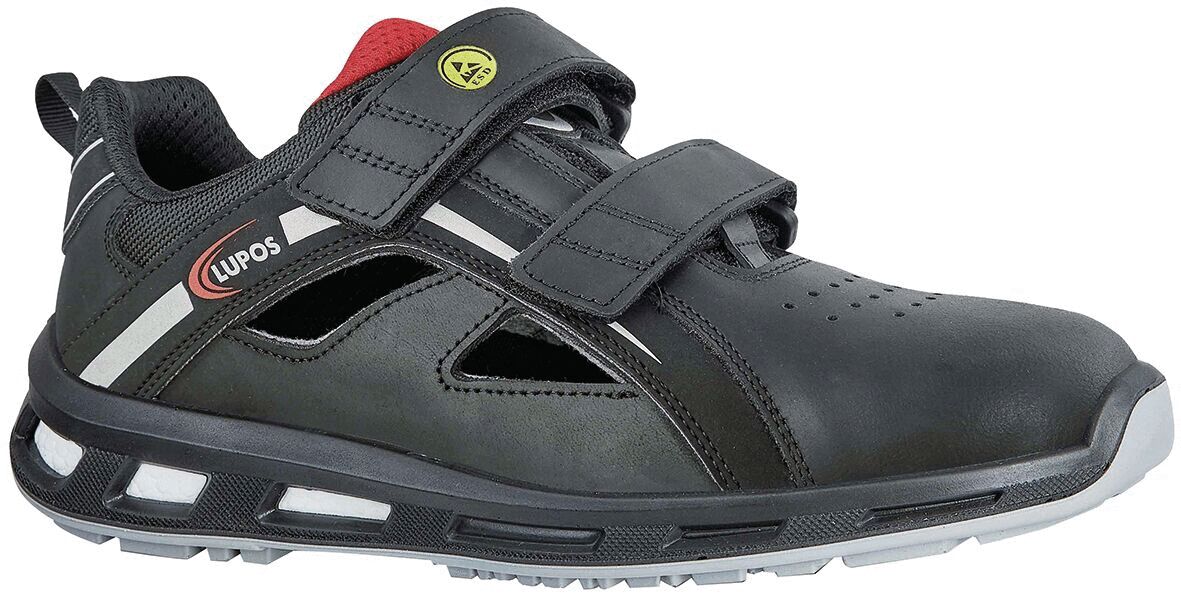 Der Schuh ist schwarz mit grauen und roten Akzenten. Er hat zwei breite Klettverschlüsse und ein luftiges Design mit seitlichen Löchern. Die Sohle ist robust und leicht profiliert.