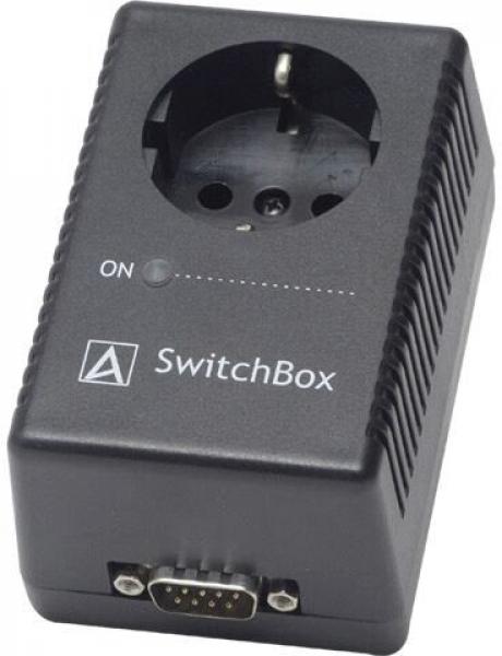 It is a black, rectangular device with an outlet on top and a serial interface on the bottom. On the side, there is a switch labeled "ON".