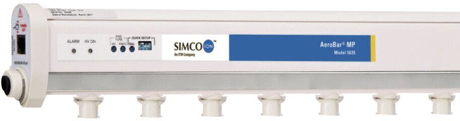 The image displays a long, rectangular device in light colors. It has multiple outputs on the bottom and controls on the front, as well as blue lettering with the name "SIMCO".