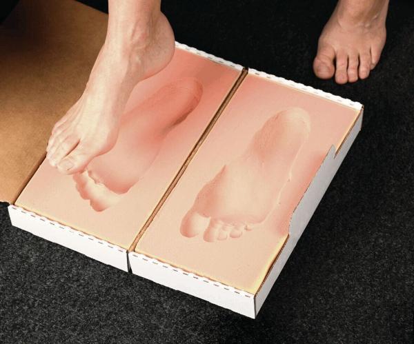 The image shows a foot placed on a special template. This template is in a cardboard box shaped like a foot with details such as toe prints.