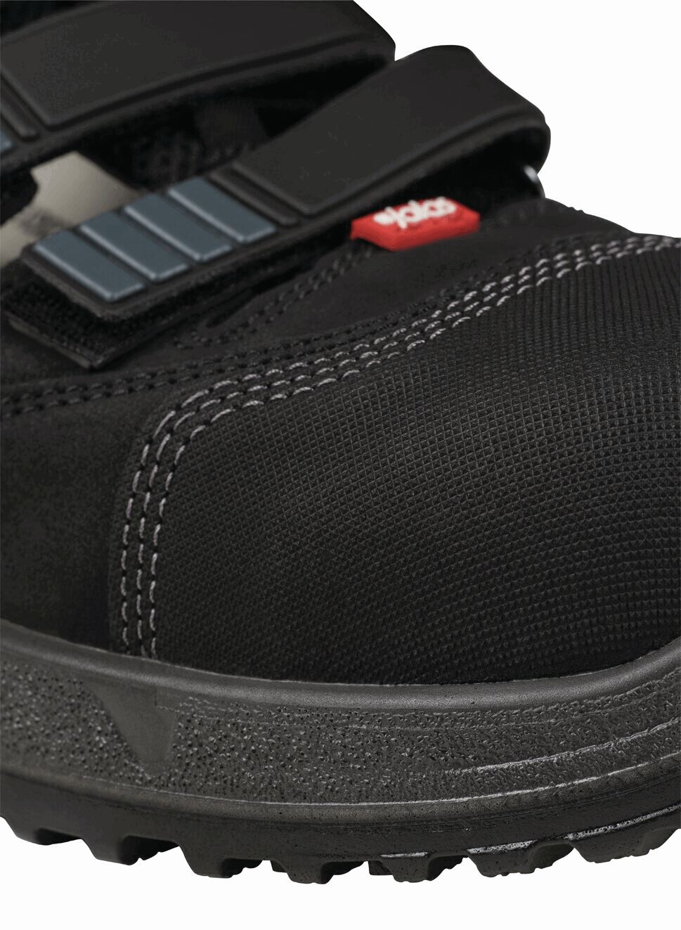 The image shows a black sports or cycling shoe with a sturdy upper. It has two black straps for closure and a grippy sole with a textured tread.