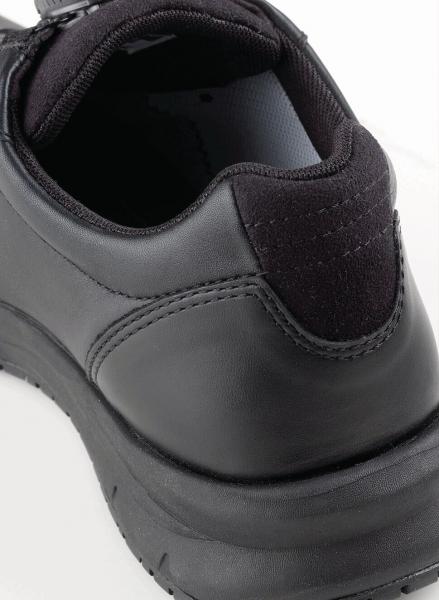 The image shows the back of a black, sporty shoe made of smooth leather. The sole is sturdy and slightly elevated, with a padded entry for comfort.