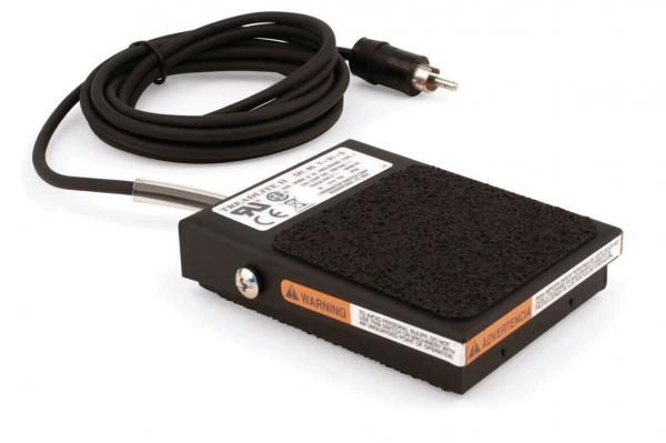 The image shows a black foot pedal with a non-slip surface. It has a cable that can be connected to an electrical device. Some technical information is displayed on the top.