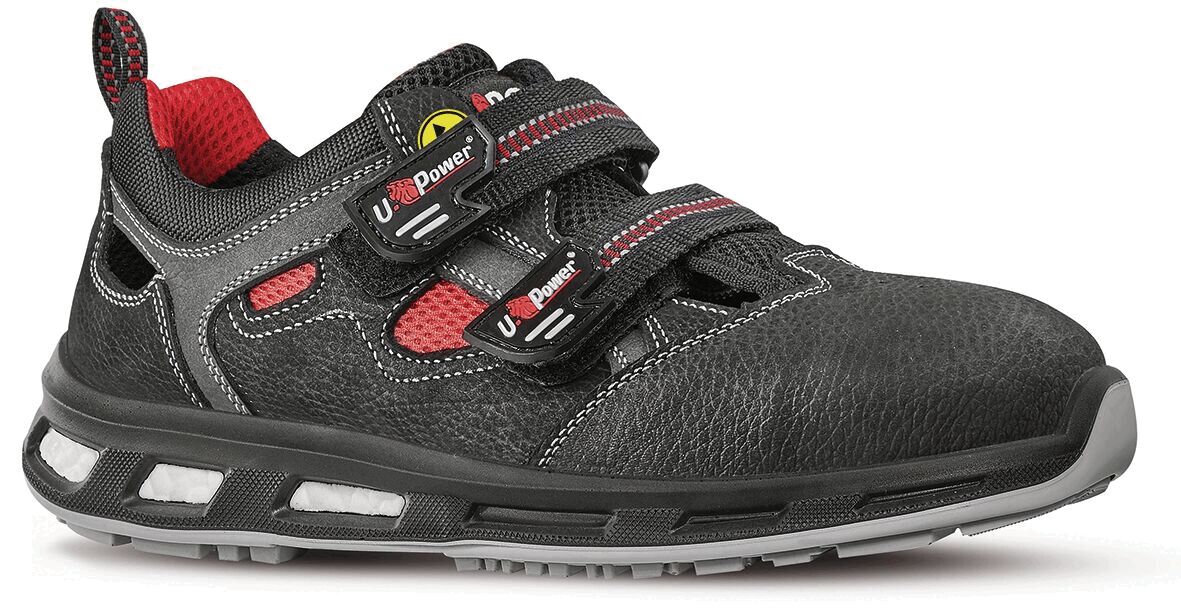 The shoe is black with gray and red accents. It has two wide Velcro straps and a non-slip sole. The mix of materials ensures comfort and durability.