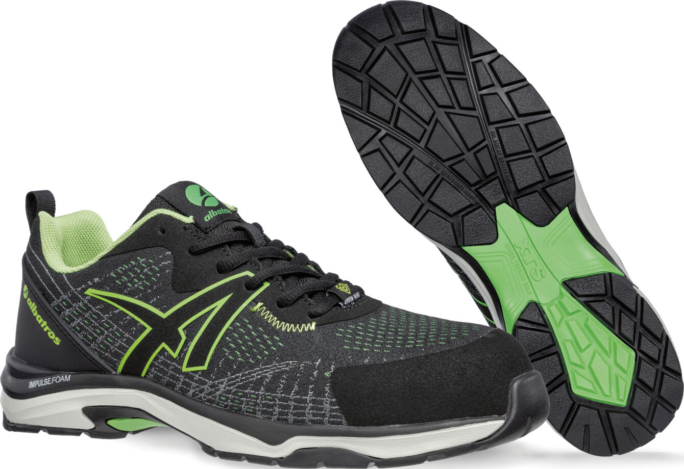 The image shows a pair of athletic shoes. They are primarily black with green accents. The sole has a non-slip pattern, and the shoes appear lightweight and breathable.