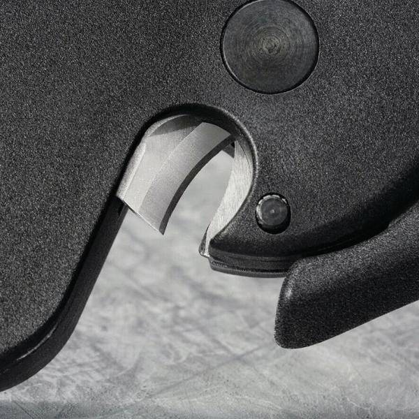 The image shows a section of a black, solid surface with a silver metal part. The shape resembles a blade or a mechanism, embedded in the black mount.