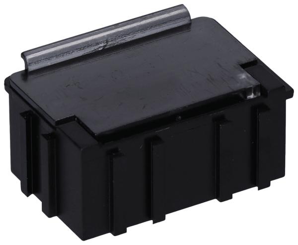 The image shows a compact, rectangular, black box with a smooth top and a metallic flap on the back. The sides are ridged.