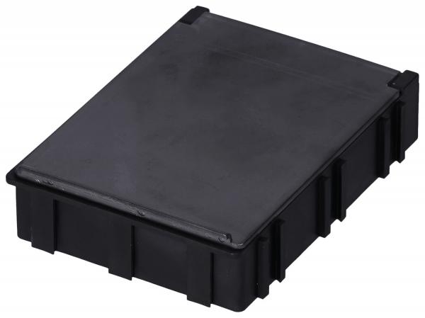 The image shows a rectangular, flat box made of black plastic. It has a smooth top and side grooves or indentations that give it structure.