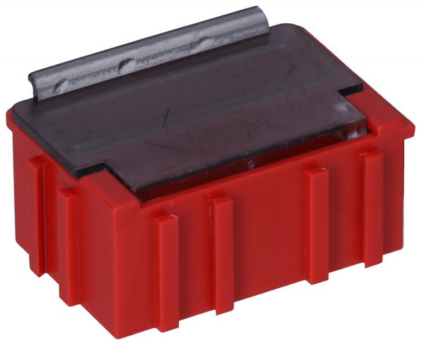 The image shows a red, rectangular container or connector with a metallic top. The corners are rounded, and the sides have vertical grooves.