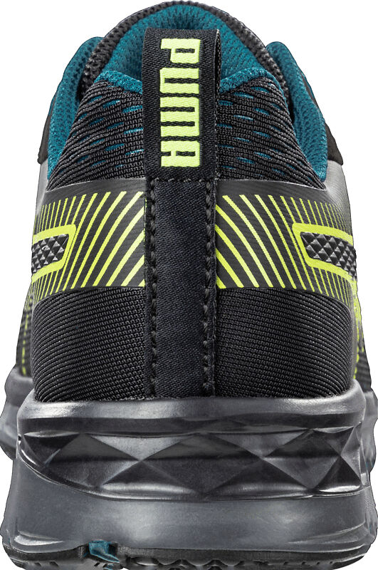 The image displays the rear view of a black sports shoe with yellow and green accents. The upper part features a textured design and the shoe has a grippy, treaded sole.