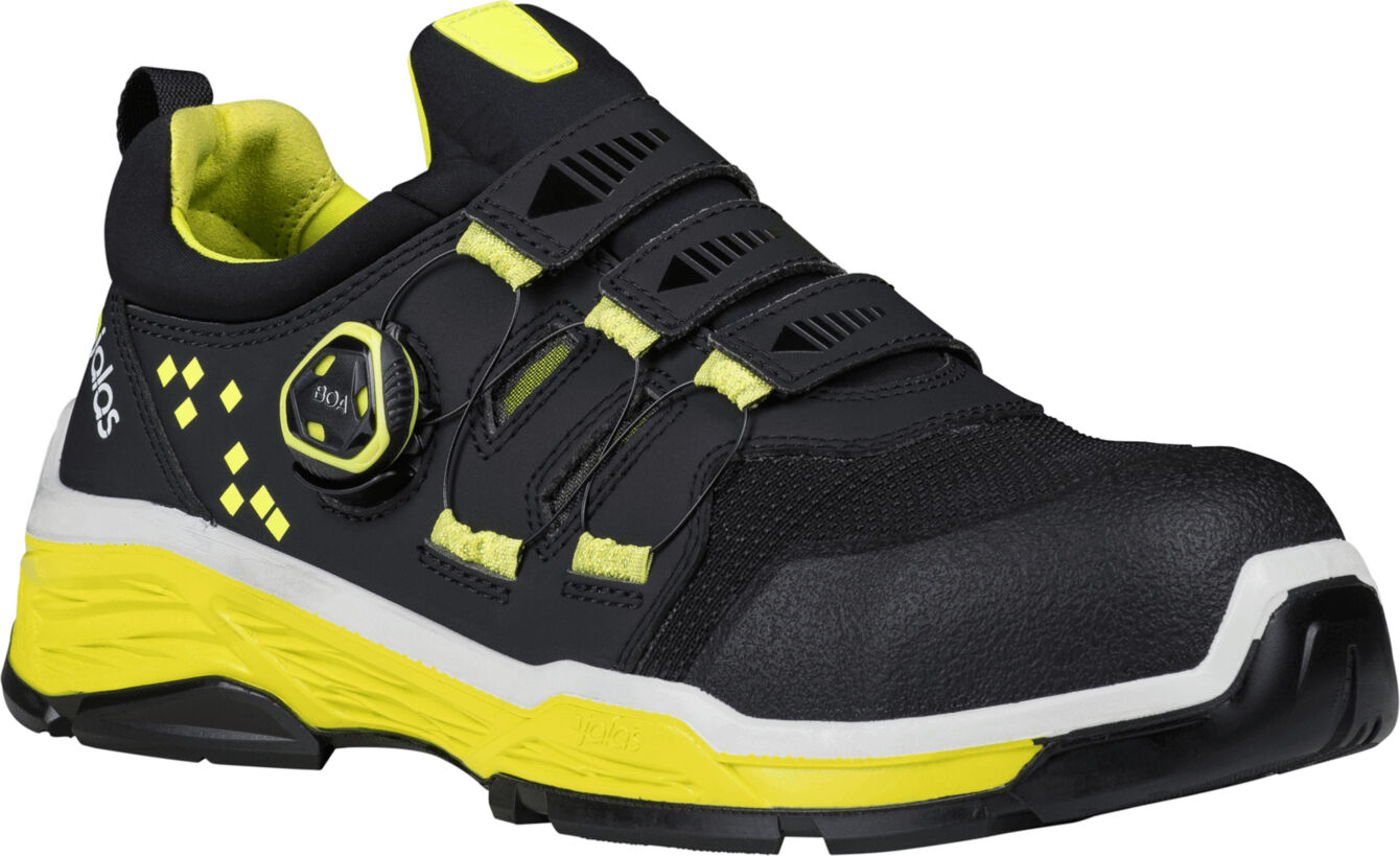 The shoe is black with yellow accents. It has a sporty shape, flat sole, and a quick-release system with laces. The upper part is lightly padded and stable.