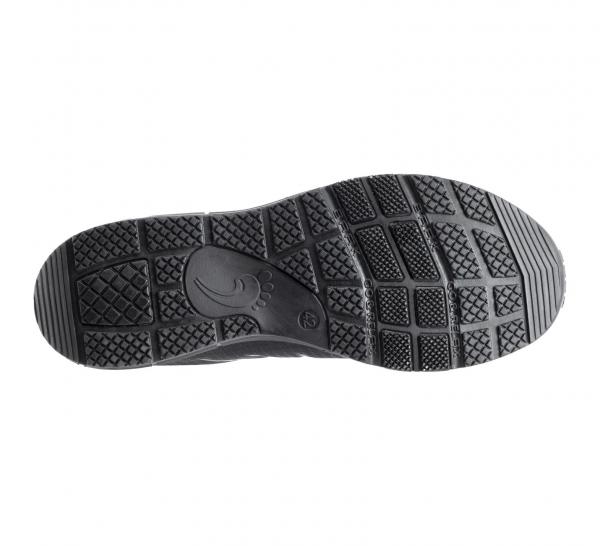 The image shows the underside of a shoe. It is made of black rubber with a textured tread that includes various grooves and patterns to provide grip.