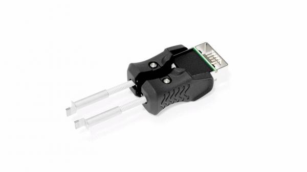 Das Bild zeigt einen Adapter mit zwei silbernen Stiften und einem schwarzen, ergonomisch geformten Griff. Der obere Teil hat einen Anschluss, der an einen USB-Port erinnert.