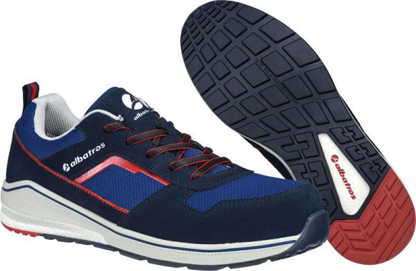 The image shows a blue sports shoe with red accents. The shoe has a white rubber sole and is equipped with laces. The sole features a textured tread for better grip.