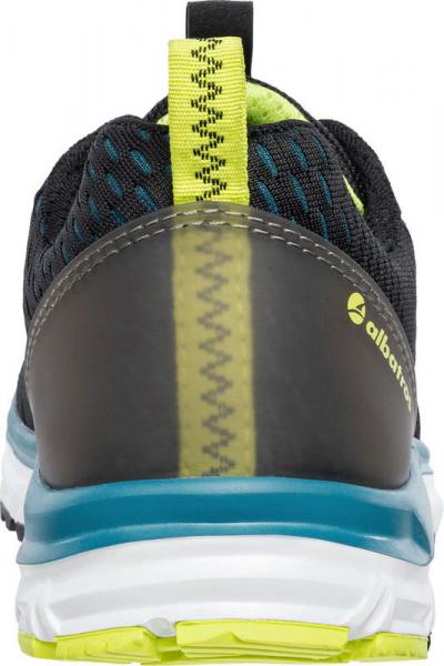 The image displays the rear view of a sporty shoe. It is black with yellow and blue accents. The sole is wide and light, and the heel area has a textured surface.