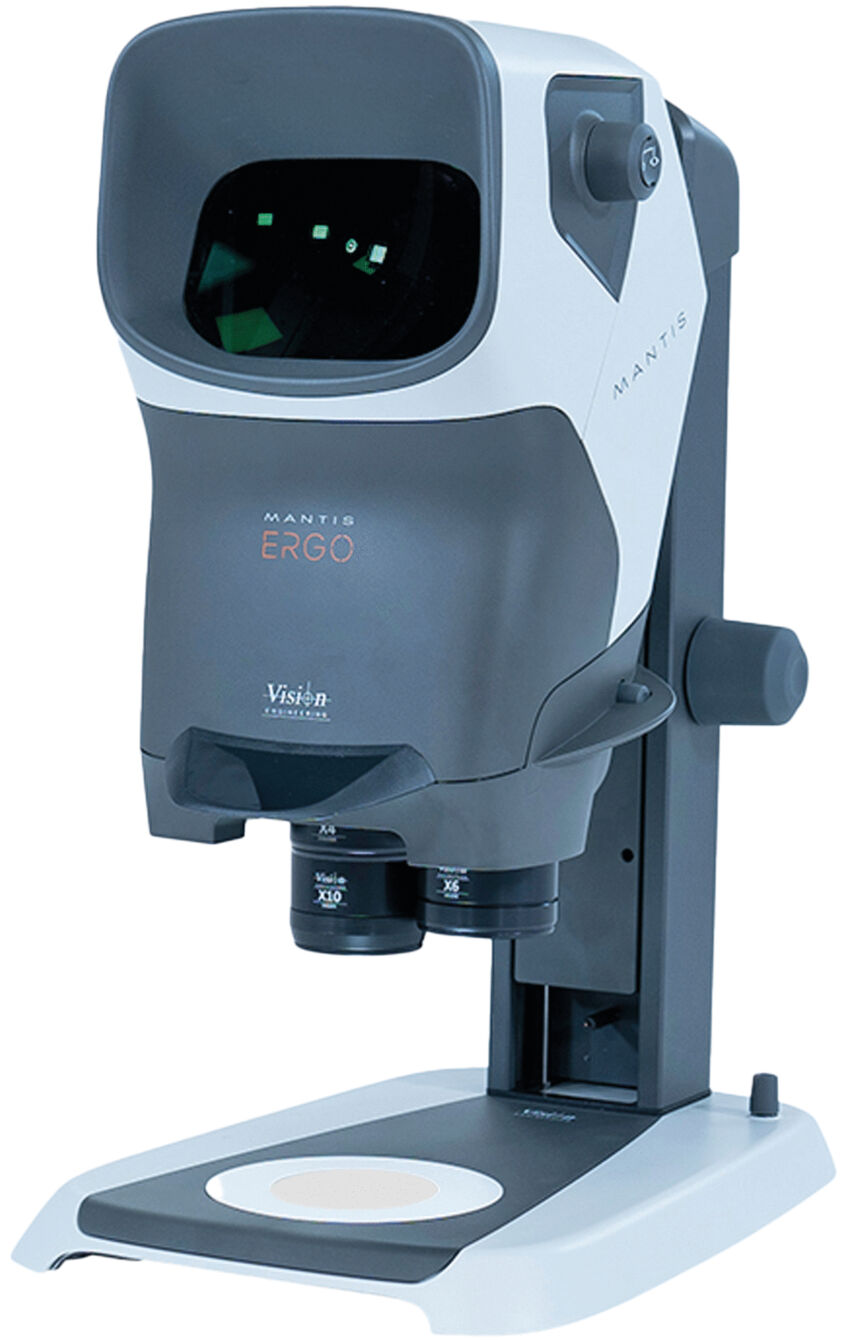 The image shows a modern microscope. It has a rectangular shape with a large viewing window at the top and two eyepieces. The base is flat and stable, with a round area for samples.