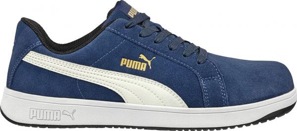 Der Schuh ist ein sportlicher Sneaker in dunklem Blau mit weißen und goldenen Details. Er hat eine flache Sohle, eine klassische Schnürung und das Puma-Logo auf der Seite.