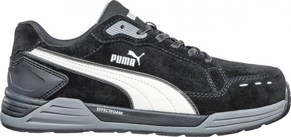 Der Schuh ist ein sportlicher Sneaker in Schwarz mit grauen und weißen Akzenten. Er hat eine atmungsaktive Oberfläche aus Wildleder und eine dicke, griffige Sohle. Markenzeichen: das Puma-Logo.