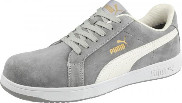 The shoe is a gray sneaker made from soft upper material with a white sole. It has a classic shape, laces, and a golden logo on the side.