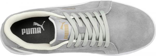 The image shows a gray sneaker made of soft suede. It has green laces and a light-colored insole. The logo is prominently displayed on the side.