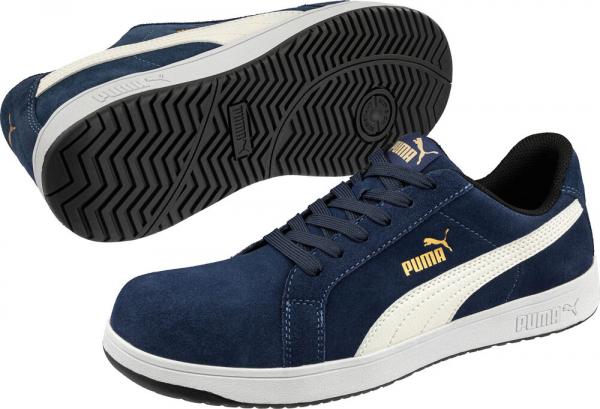 The image shows a pair of sporty sneakers in navy blue with white and gold accents. The shoes feature a smooth, padded surface and a non-slip rubber sole.