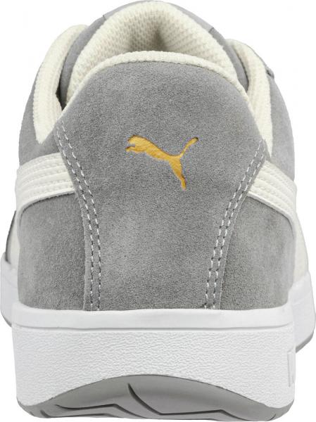 Das Bild zeigt die Rückansicht eines grauen Sneakers. Er besteht aus weichem Material, hat eine helle Sohle und ein goldenes Puma-Logo auf der Ferse.