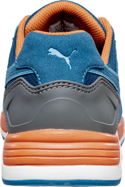 The image shows the rear view of a blue sports shoe with gray and orange accents. The shoe has a soft, padded heel and a textured sole.