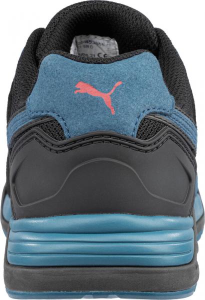 The image displays the back of a sports shoe. The shoe is predominantly black with blue accents. A small, pink Puma logo is visible. The sole features a tiered, thick structure.