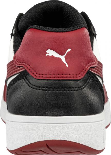 The image shows the back of a sneaker. The colors are black, red, and white. On the heel, there is the Puma logo in white on a red background. The sole is light and flat.