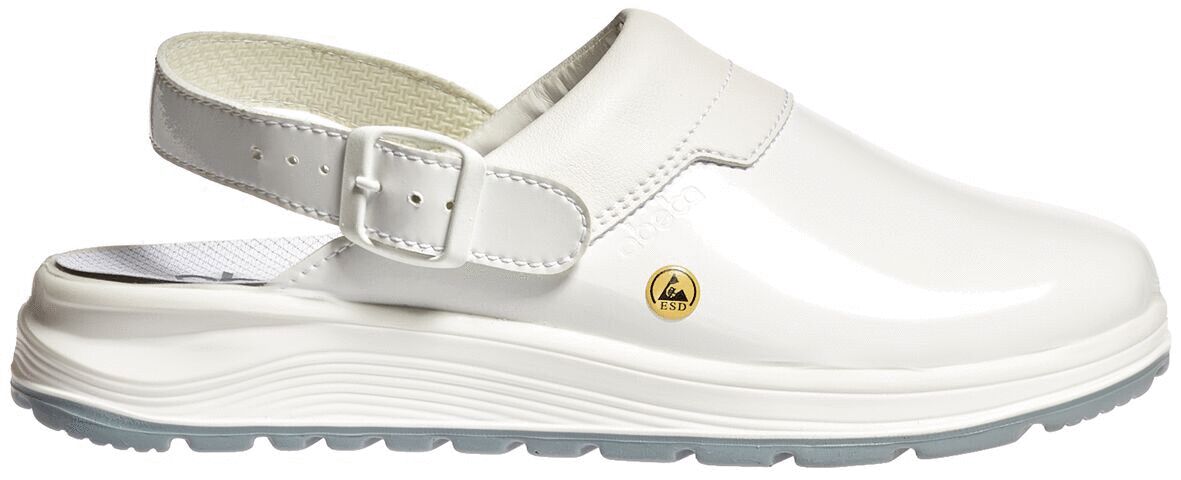 The image shows a white clog with a wide, narrow strap and a removable sole. The surface is shiny, and there is a small logo on the side.