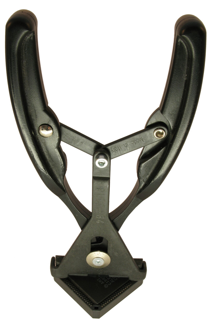 The image shows a black, plastic clamping mechanism with two curved handles and a triangular clamping surface. It is used to secure materials while working.