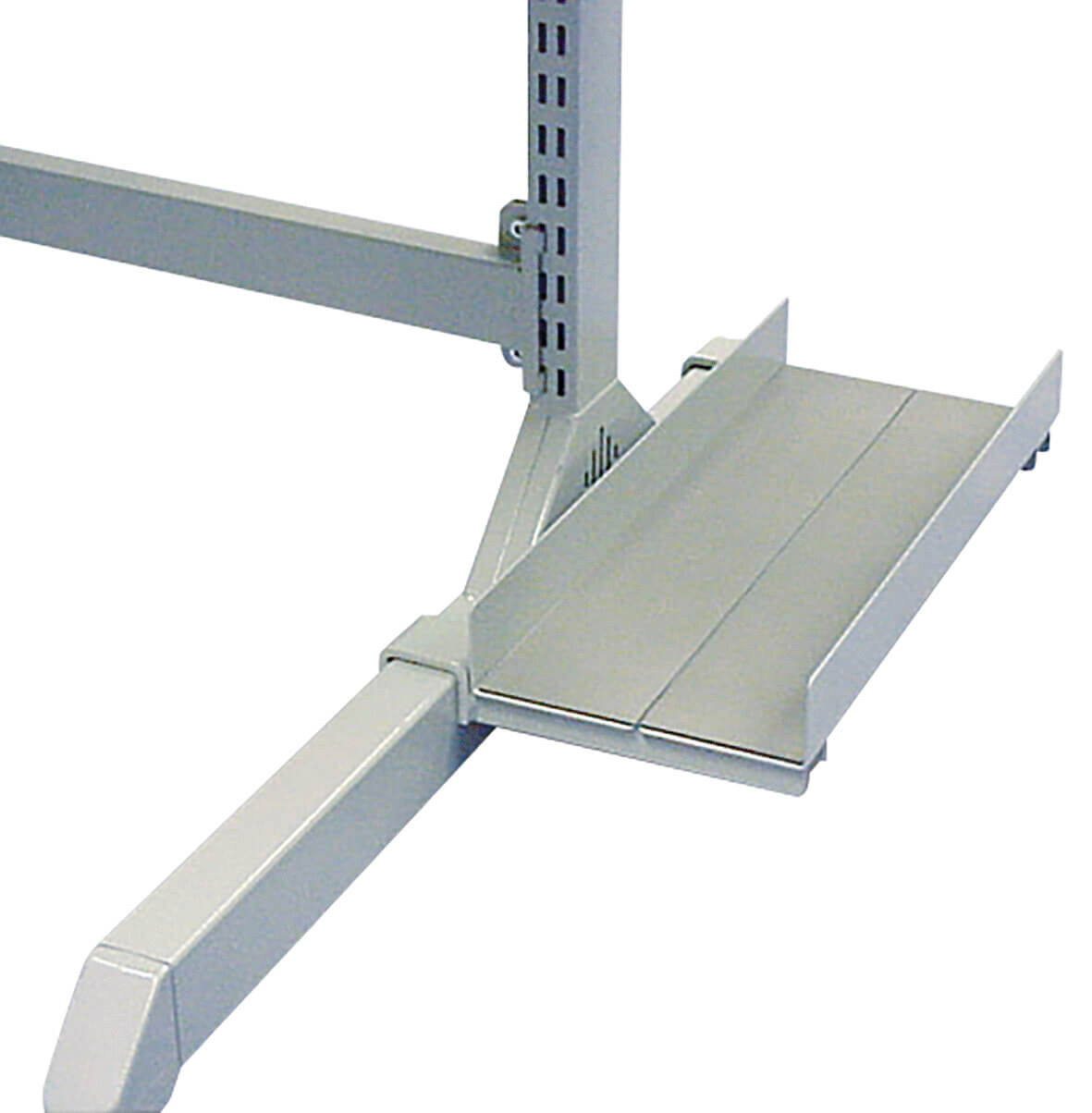 The image shows a metal desk pad. It has a simple, gray surface and a slightly beveled front edge. A support connects it to a sturdy table frame.