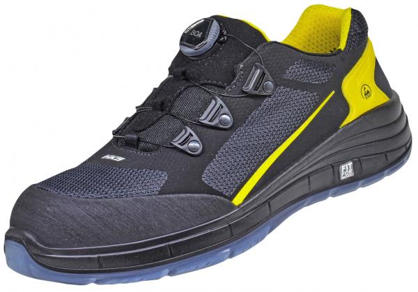 The shoe is sporty, with a black surface and yellow accents. It has a comfortable, padded sole and a quick lacing system with three visible elements. Ideal for activities.