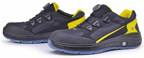 The image shows a pair of athletic shoes in black with yellow accents. They feature a modern shape, breathable material, and a rubber sole with good grip. Closure with a convenient quick-lacing system.