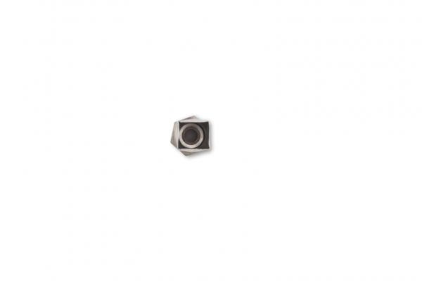 The image shows a hexagonal nut lying on a white background. The nut has a black recess in the center and appears to be made of metal.