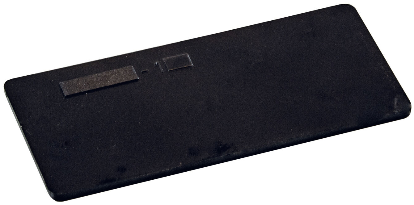 The image shows a rectangular, flat object in black, featuring a smooth surface and a small opening. It is designed to be simple and inconspicuous.