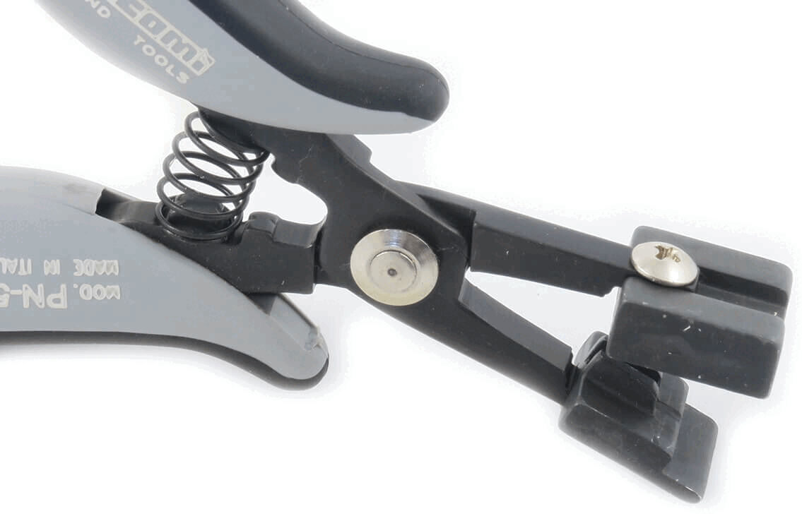 The image shows a gray pair of pliers with a spring-assisted mechanism. The handle ends are black, and there is a small screw in the middle. It is probably used for cutting or gripping.