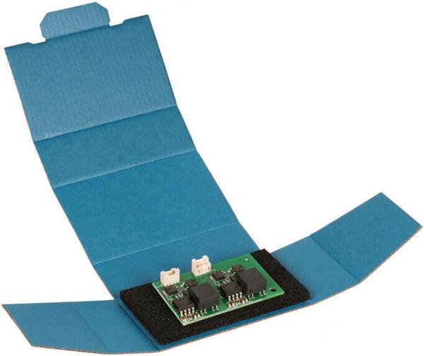 The image shows a green circuit board with several black components, on a blue packaging. The circuit board is mounted on a black foam cushion.