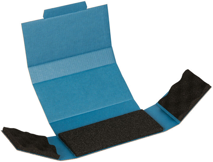 The image shows an open, blue cardboard box with two side flaps. In the center, there is a black, rough piece of material that appears to be used for adhesive purposes.