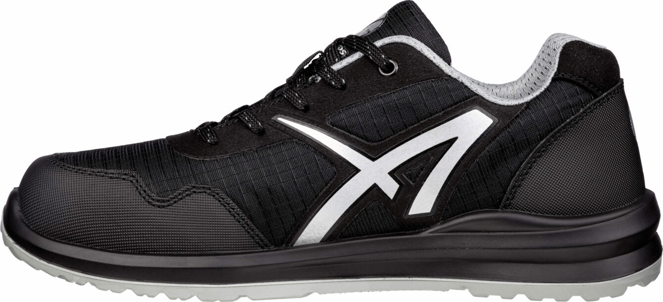 The shoe is sporty, predominantly black with gray and white details. It has a sturdy sole, a padded tongue, and laces. The surface is textured and breathable.