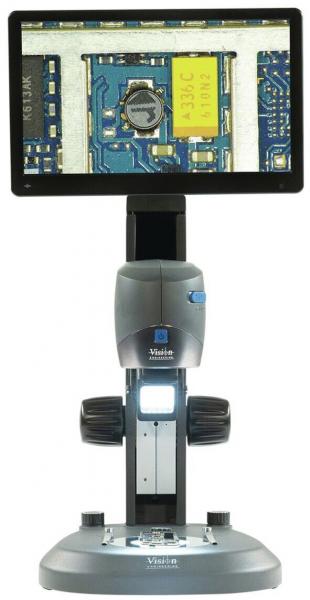 The image displays an electronic microscope. At the top, there is a large screen showing a circuit board. Below, the microscope is designed with a stable base and control elements.