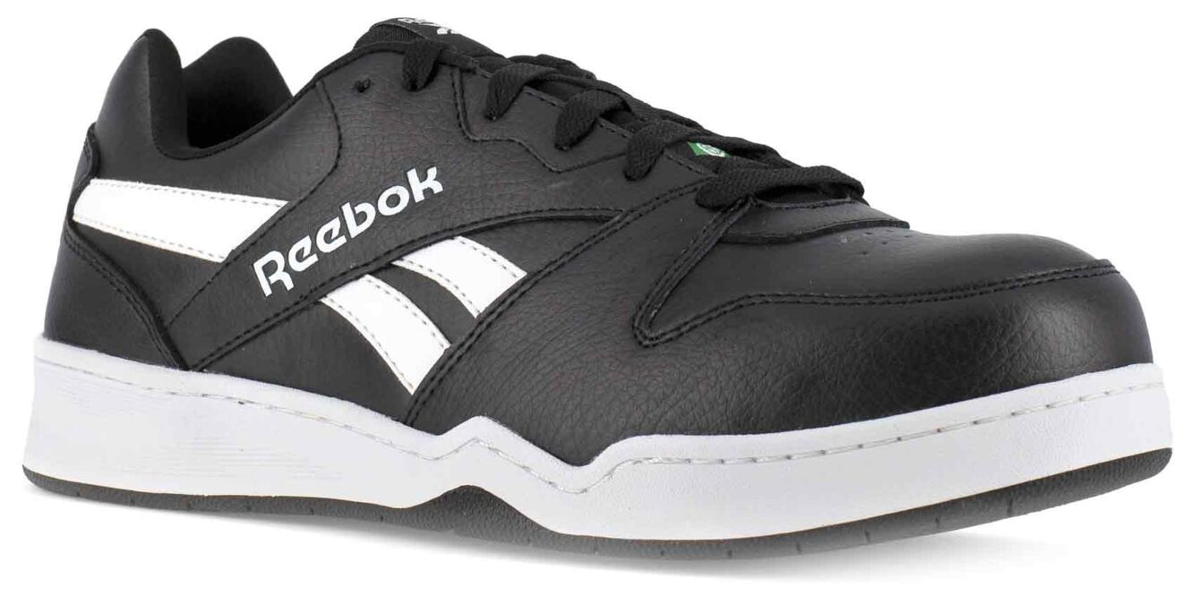 The image shows a black leather Reebok sports shoe. It features white details and a flat, grippy sole. The laces are black, and the design is sporty and modern.