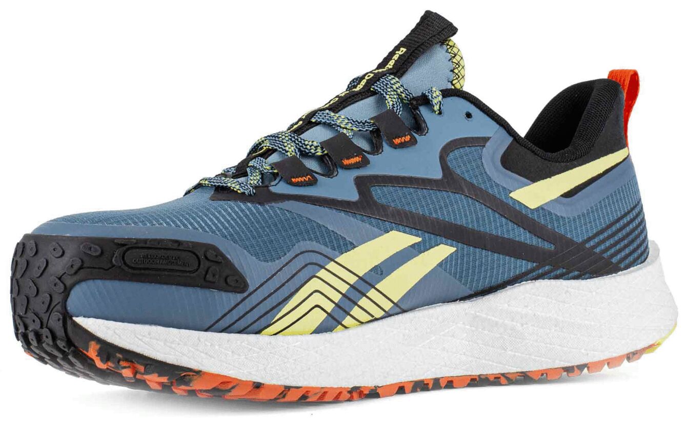 The shoe is a sporty running shoe in blue with yellow and black accents. The sole is white and features an orange, textured underside for better grip.