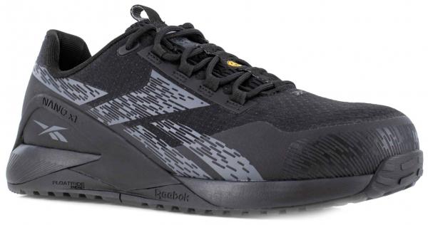 The image shows a black athletic shoe with gray and black patterns. It has a flat sole and a padded tongue. The laces are black and the shoe appears sturdy and modern.