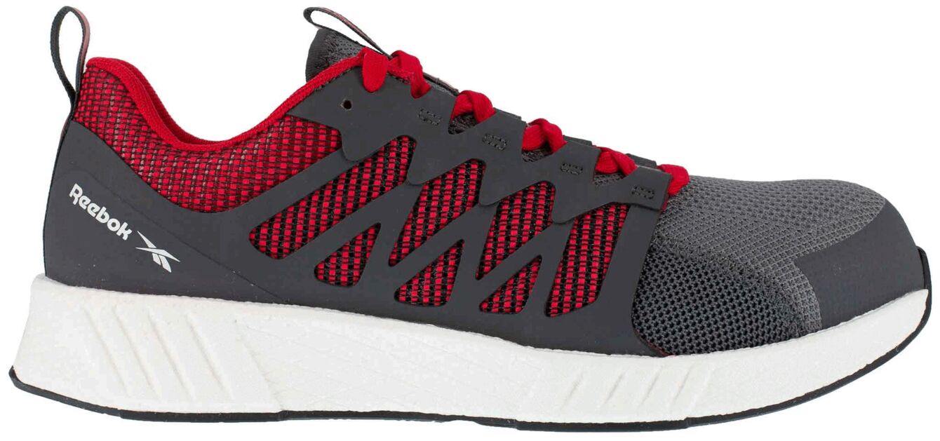 The shoe is lightweight and sporty with a gray and red color scheme. It has a textile upper and a grippy, white sole. The laces are red, the side structure is breathable.