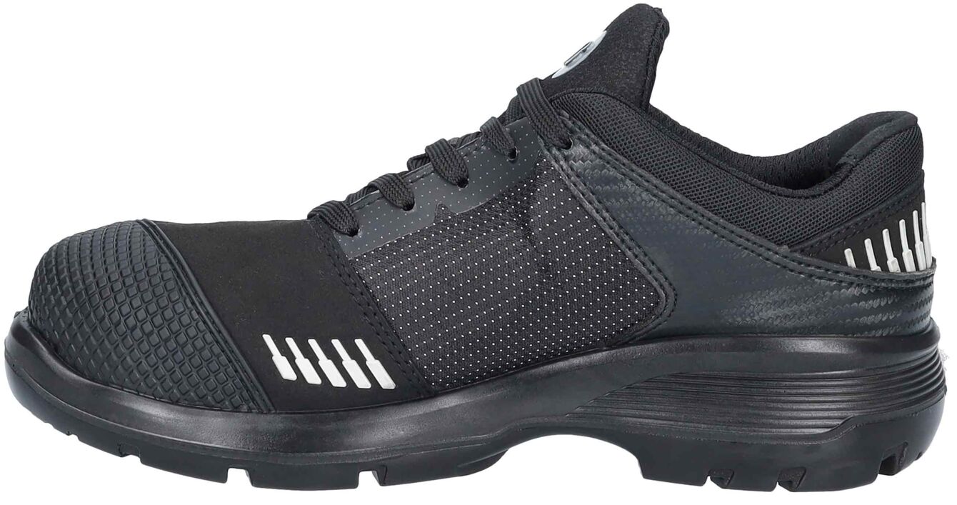 The shoe is a black sports or safety shoe. It has a non-slip sole, padded tongue, and a reinforced toe. The sides are adorned with small, reflective dots.