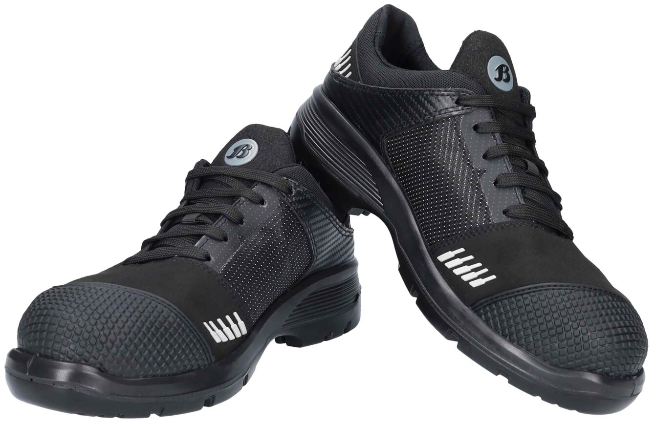 The image shows a pair of black safety shoes. They have a sporty shape, a padded sole, and reinforced toe protection. The surface features various textures and patterns.