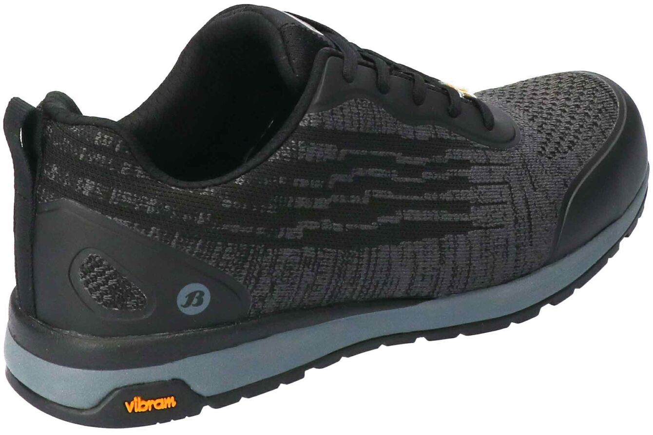 The shoe is a sporty, black sneaker with a textured upper. It features a cushioned sole for good grip, and a gray outsole with the "Vibram" logo.