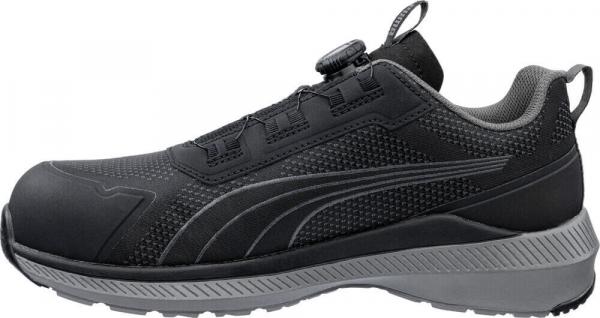 The shoe is black with gray accents. It has a sturdy sole, a breathable upper, and a convenient quick-lacing system. The shape is sporty and modern.